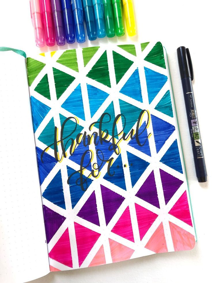 an open notebook with markers and pens next to it