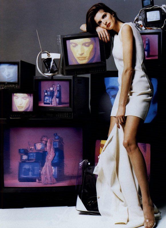 a woman is standing in front of televisions