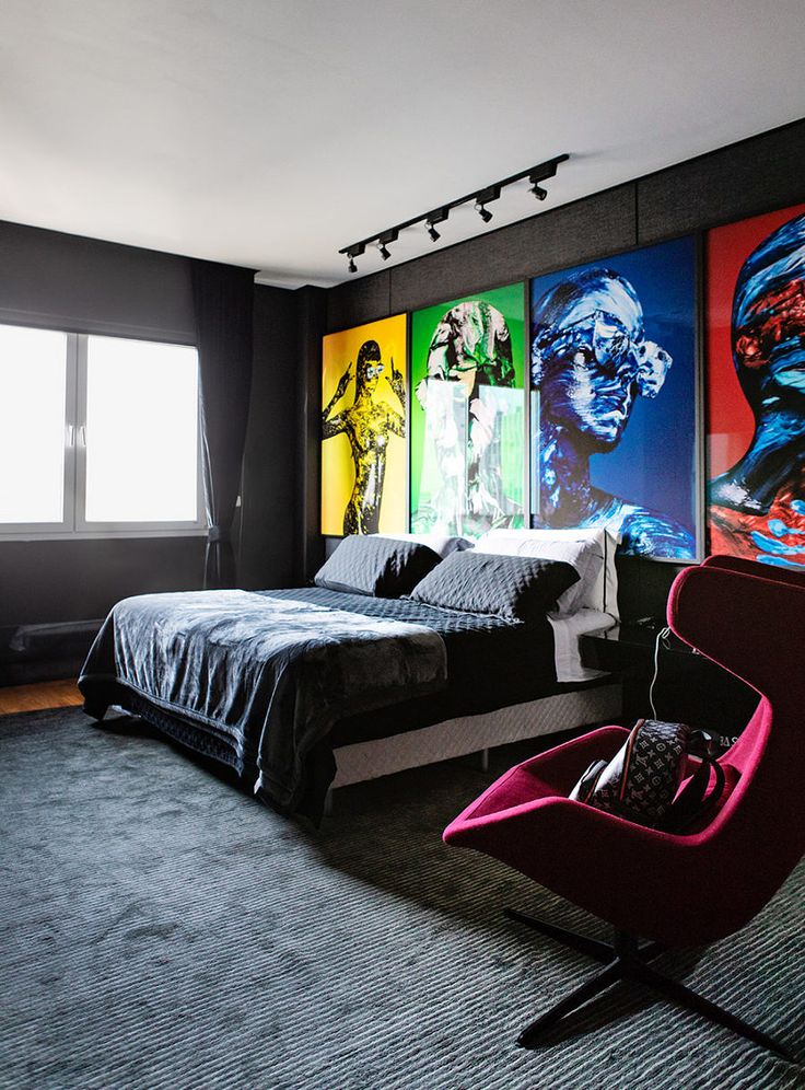 a bedroom with black walls and paintings on the wall