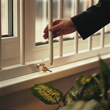 a person is holding a candle in front of a window with bars on the windowsill