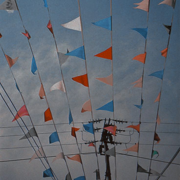 many colorful flags are flying in the air above power lines and telephone poles on a cloudy day