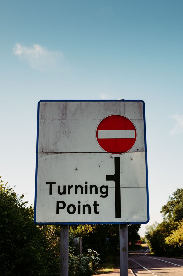 a street sign that says turning point with trees in the back ground and blue sky behind it