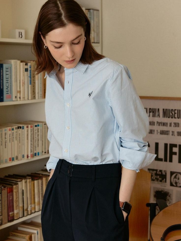 The basic striped shirts featuring the straight fit and comfortable silhouette. The oxford fabric and regular thickness create classic fit, and the logo embroidery added a stylish mood to the shirts. Style with various kinds of bottoms like trousers, denim jeans, or skirts to complete the classic outfits. - Blue stripe pattern throughout the shirts- Straight fit and comfortable silhouette- Logo embroidery at chest- Button closure detail at front- Two-button barrel cuffs Oxford Shirt Women Outfit, Classic Blue Shirt With Striped Collar, Blue Cotton Top With Striped Collar, Blue Button-up Shirt For Daywear, Button Shirt Outfit, Casual Blue T-shirt With Striped Collar, Oxford Shirt Women, Blue Stripes Pattern, Blue Cotton T-shirt With Contrast Stripes