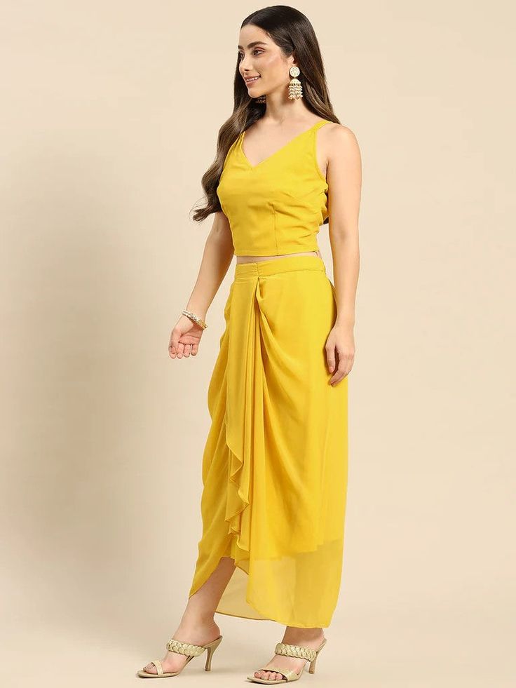 Look your absolute best as you head out this festive season wearing this Fusion Set. Crafted using the finest georgette fabric, this apparel will surely make you stand out. Complement this outfit with a pair of high-heels and chunky gold jewelry to complete your look. Material: Georgette Wash Care: Dry-clean Pattern: Printed Style: Crop Top With Dhoti Skirt Set, Crop Top With Dhoti Skirt And Jacket/Shrug Set, Dhoti Suit Set, Indo Western Dress, Indian Dress For Women Sizes: To Fit Bust(in inches Party V-neck Georgette Pre-draped Saree, Party V-neck Pre-draped Georgette Saree, Festive Draped Chiffon Saree, Sleeveless Summer Festive Pre-draped Saree, Summer Bollywood Pre-draped Saree, Summer Festive Sleeveless Pre-draped Saree, Elegant Georgette Skirt With Traditional Drape, Festive Sleeveless Georgette Set, Elegant Yellow Pre-draped Saree For Party