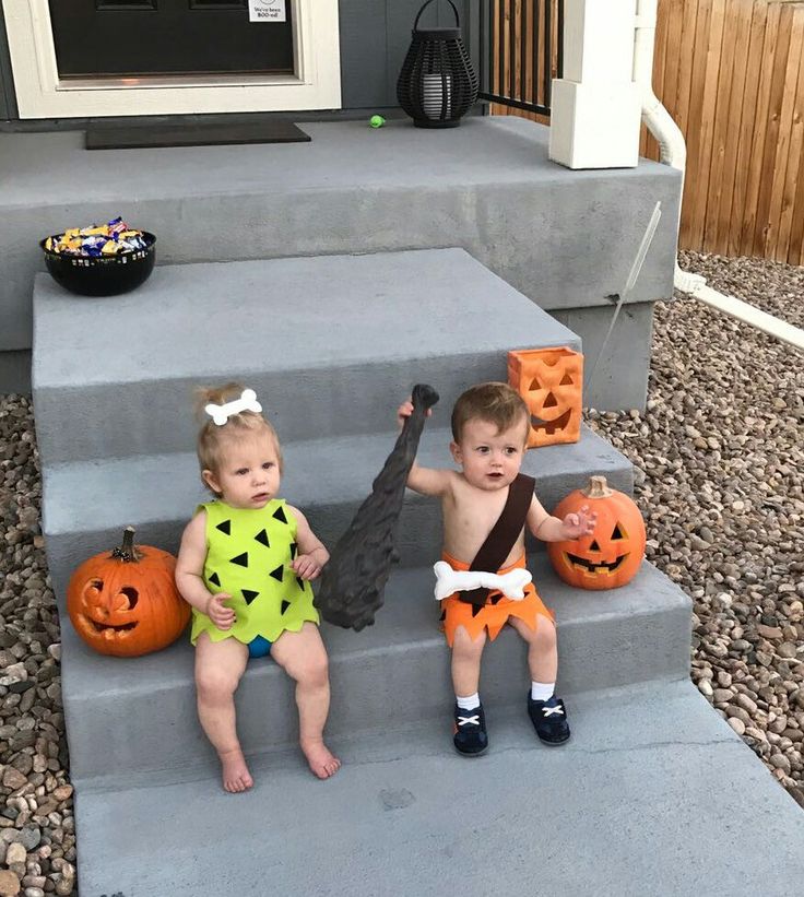 two toddlers sitting on steps decorated with pumpkins