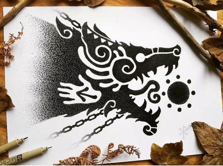 a paper with an image of a dragon on it next to leaves and crayons