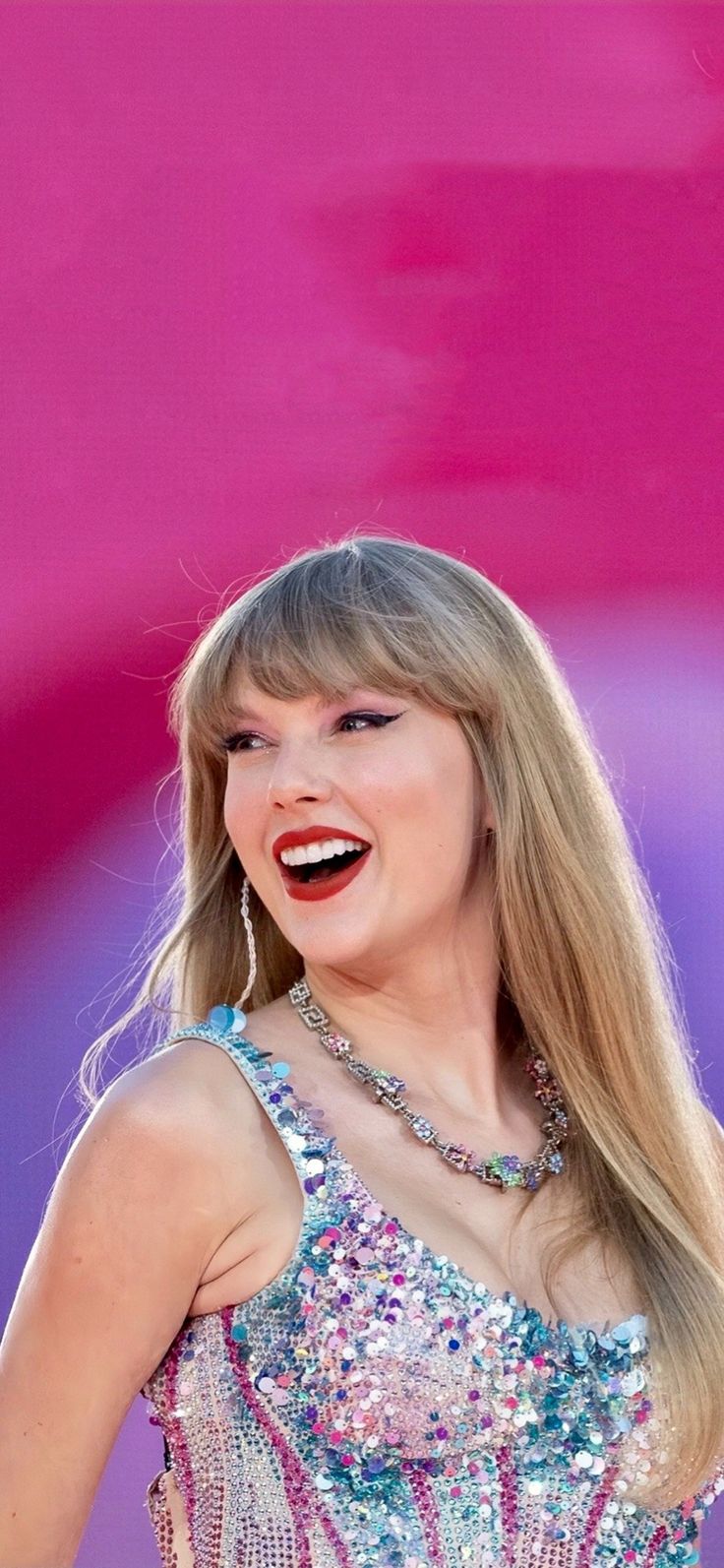 taylor swift smiling and wearing a sparky dress