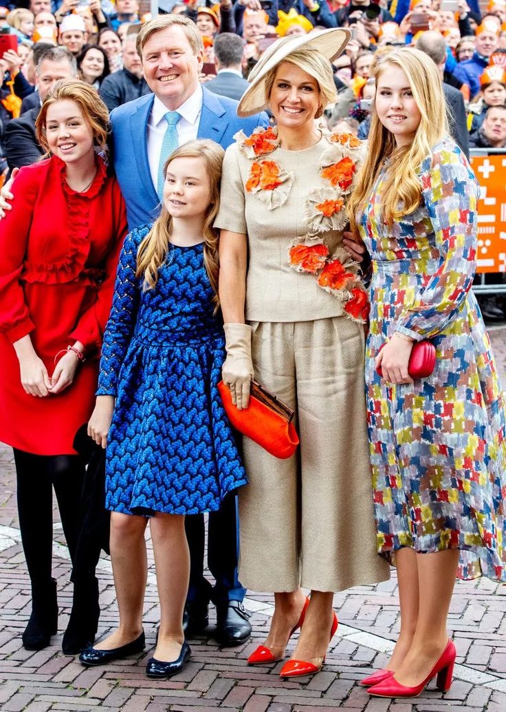 a group of people standing next to each other in front of a crowd on the street