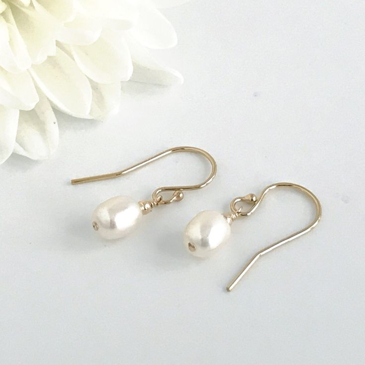 Simple, dainty classic pearl earrings are the perfect accessory to finish your look. These dainty earrings are perfect wedding jewelry for brides or bridesmaids. The total drop on these earrings is about 3/4 inches. These earrings are available in your choice of 14k rose gold fill, sterling silver or 14k gold fill. Your new earrings will arrive in a complimentary gift box. Link to matching necklace https://www.etsy.com/listing/705383905/single-pearl-necklace-tiny-oval-pearl More pearl jewelry ht Dainty Pearl White Bridal Earrings, Classic Pearl Bridal Earrings With Ear Wire, Elegant Pearl Earrings For Bridesmaid Gift, Dainty Drop Pearl Earrings For Bridesmaids, Classic Pearl Drop Bridal Earrings For Bridesmaid Gift, Minimalist Hypoallergenic Teardrop Earrings For Wedding, Gold Delicate Pearl Earrings For Bridesmaid, Classic Pearl Earrings With Ear Wire For Weddings, Delicate Pearl Earrings For Bridesmaid Gift