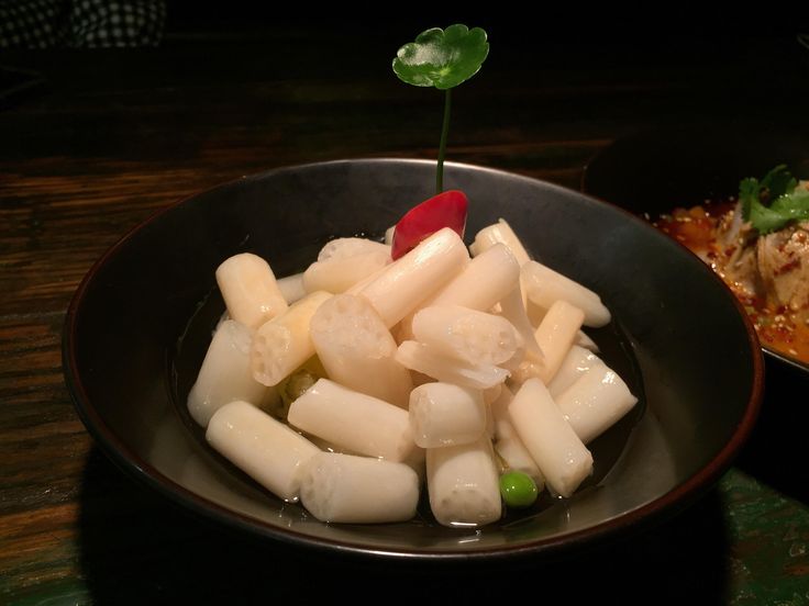 a bowl filled with food sitting on top of a table next to another bowl full of food