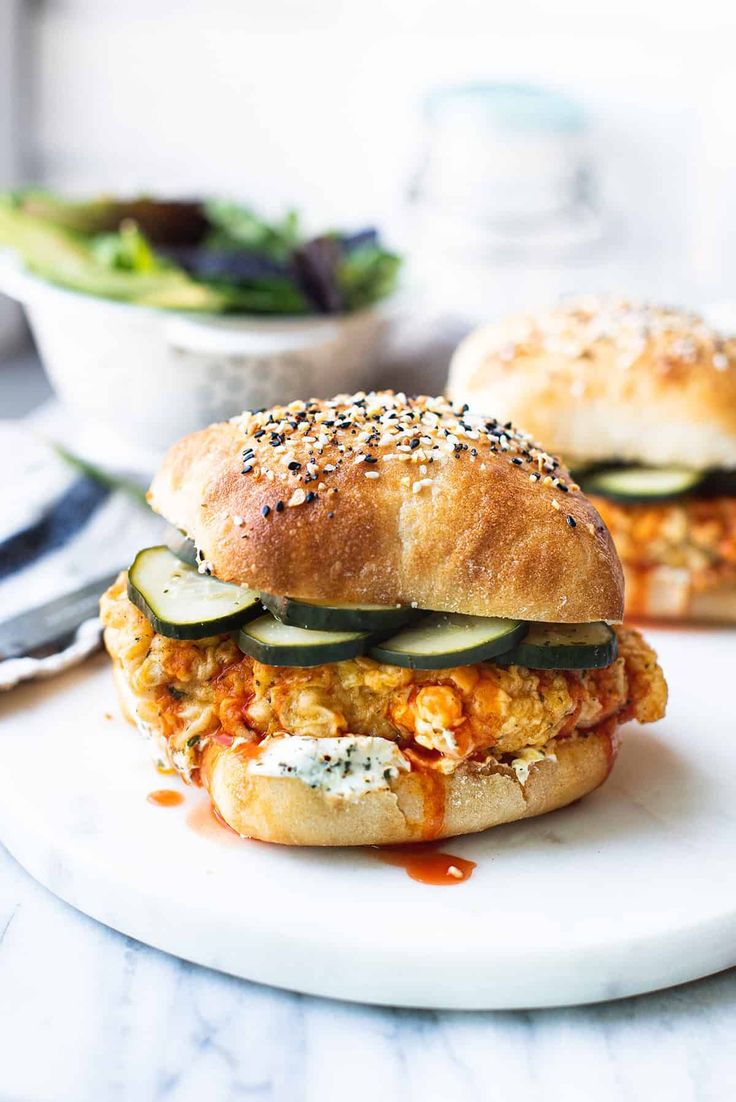 two sandwiches with cucumbers and cheese on a white plate