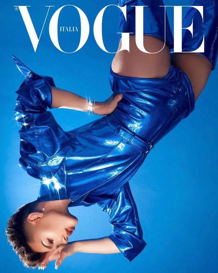 a woman in a blue dress on the cover of a magazine with her legs spread out