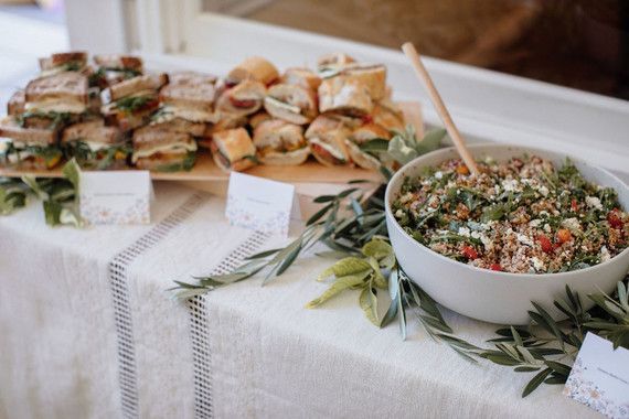 a table topped with lots of food next to a bowl of salad and crackers