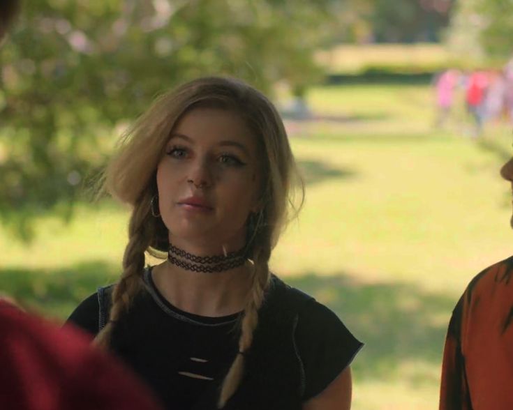 two women standing next to each other in a park