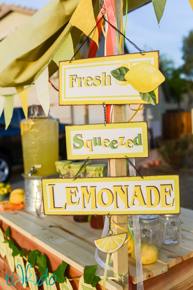 a lemonade stand is decorated with fresh squeezed lemons and signs that say it all