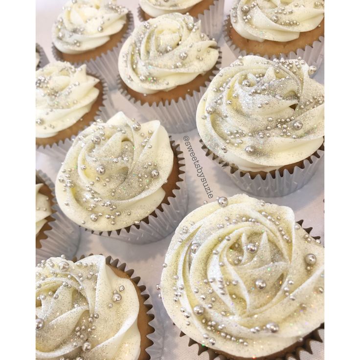 several cupcakes with white frosting and sprinkles