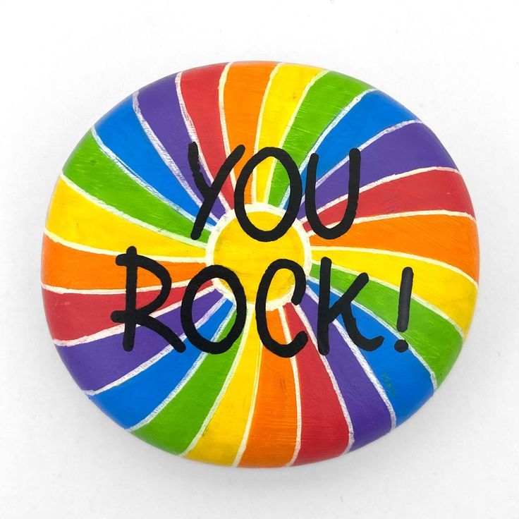 a colorful button with the words you rock written on it in black lettering, against a white background