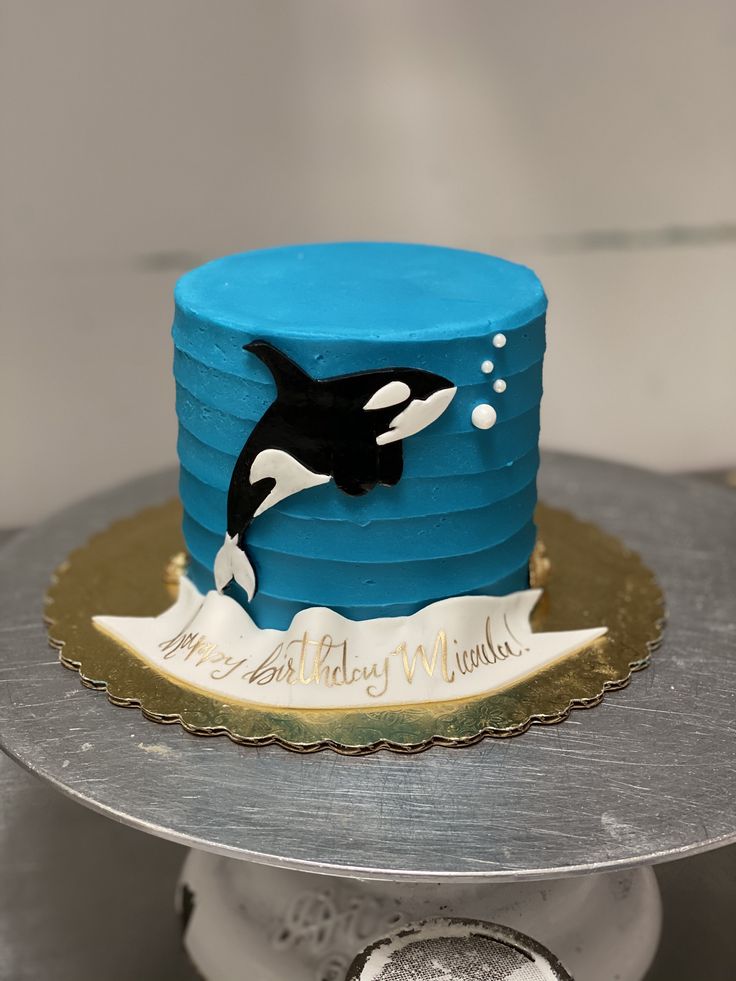 a blue cake with an orca whale on it