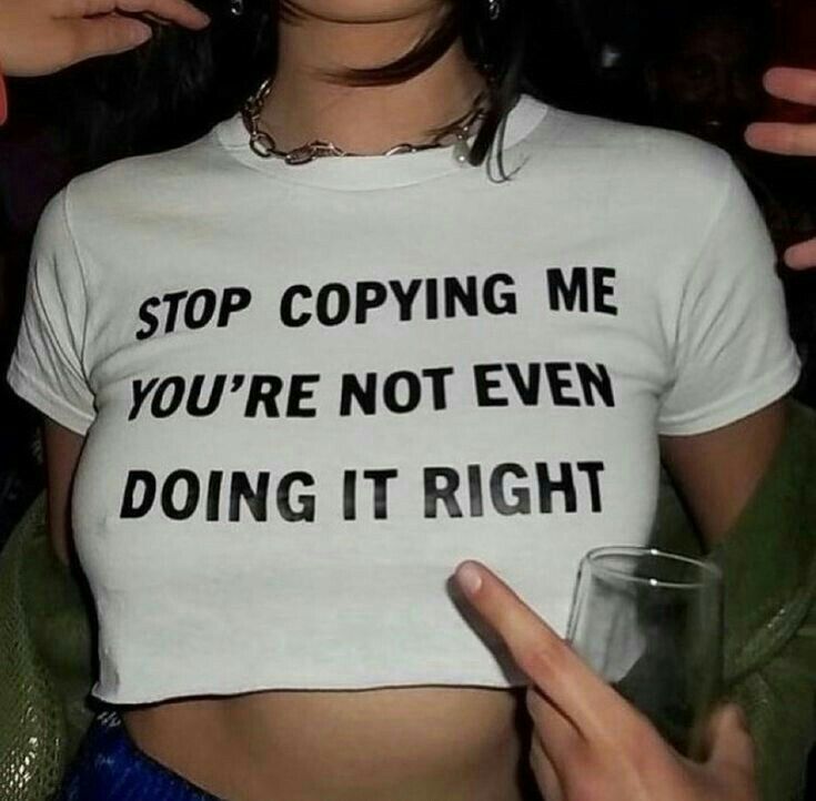 a woman wearing a t - shirt that says stop copying me you're not even doing it right