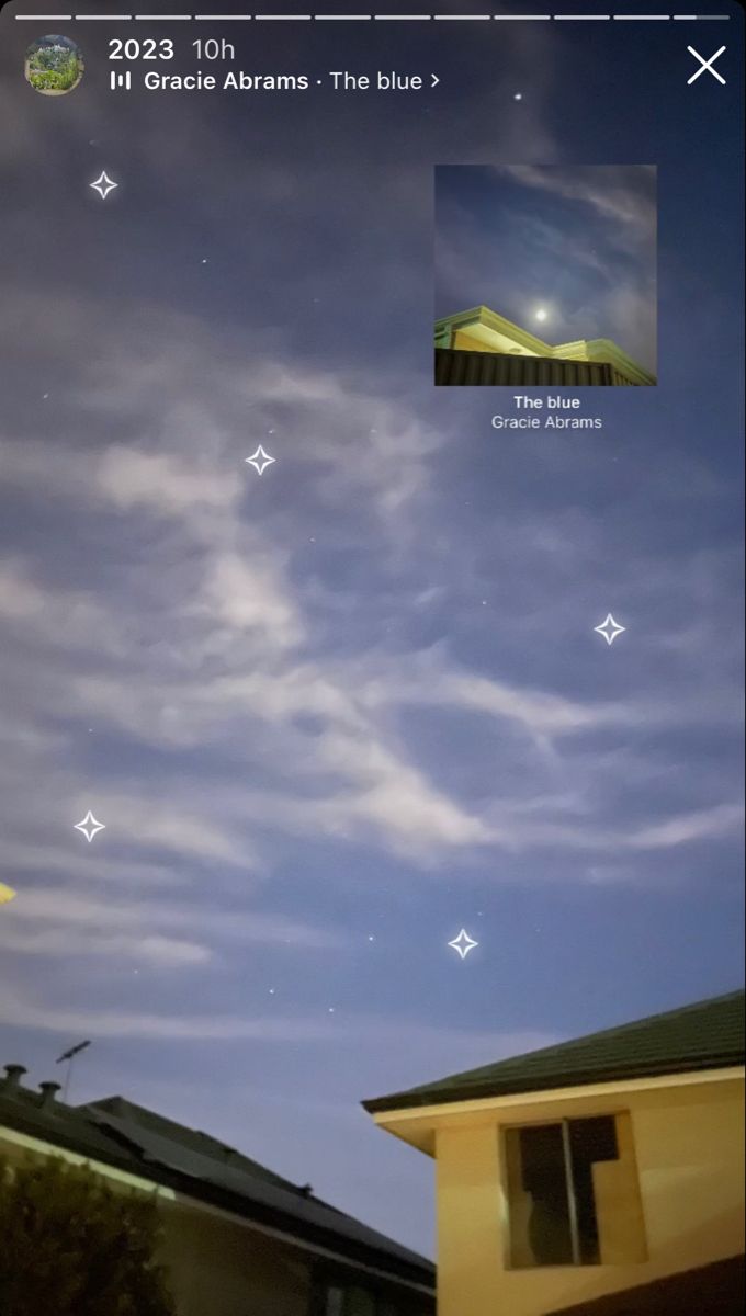 the sky is blue and there are clouds in the distance with stars above it, as well as an image of a building