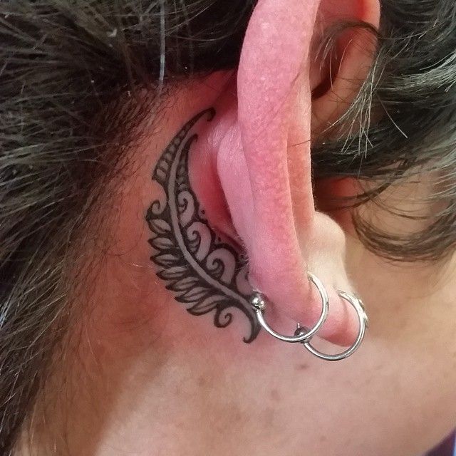 a close up of a person with a tattoo on their ear