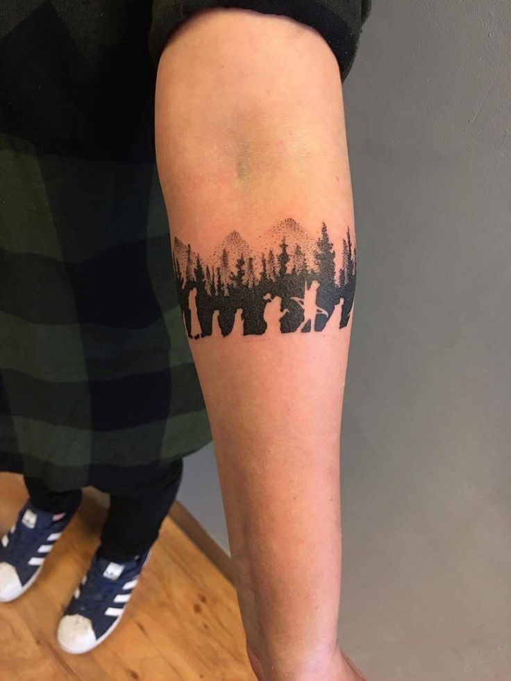 a person with a forest tattoo on their arm