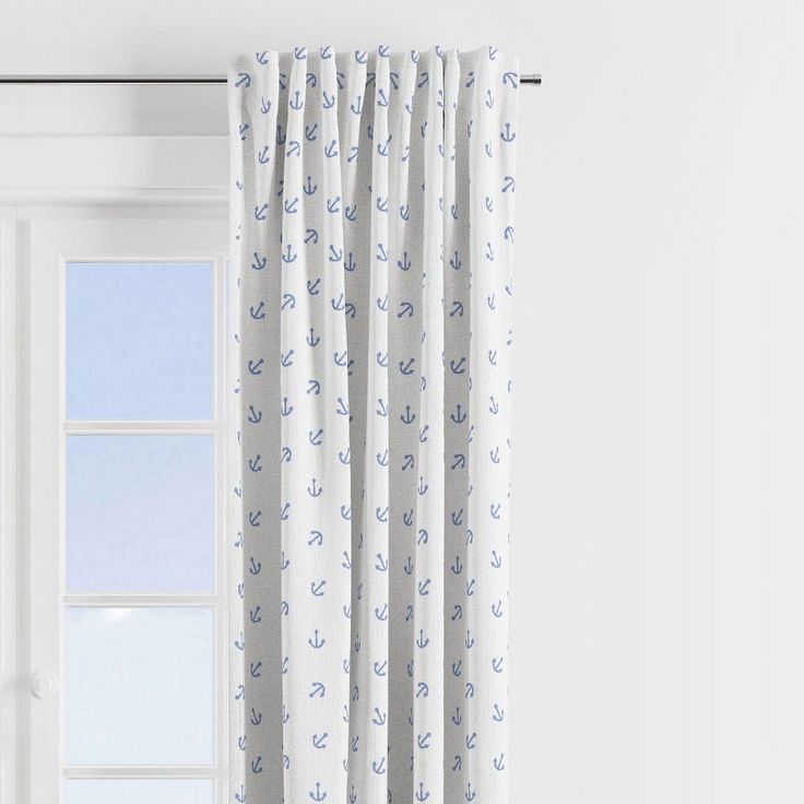 an open window with white curtains and blue anchors on the curtain rod, in front of a white wall