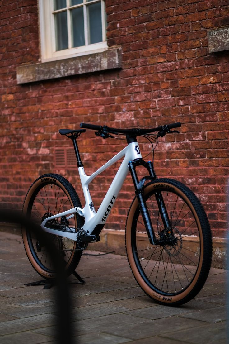 a white bike parked in front of a brick building