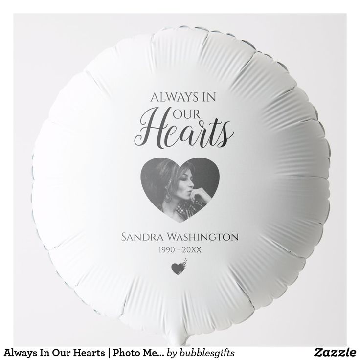 a white heart shaped balloon with the words always in our hearts printed on it and an image of a woman's face