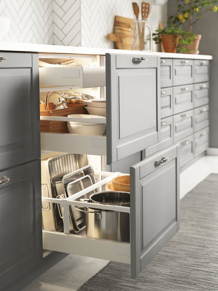 an open kitchen cabinet with pots and pans in it