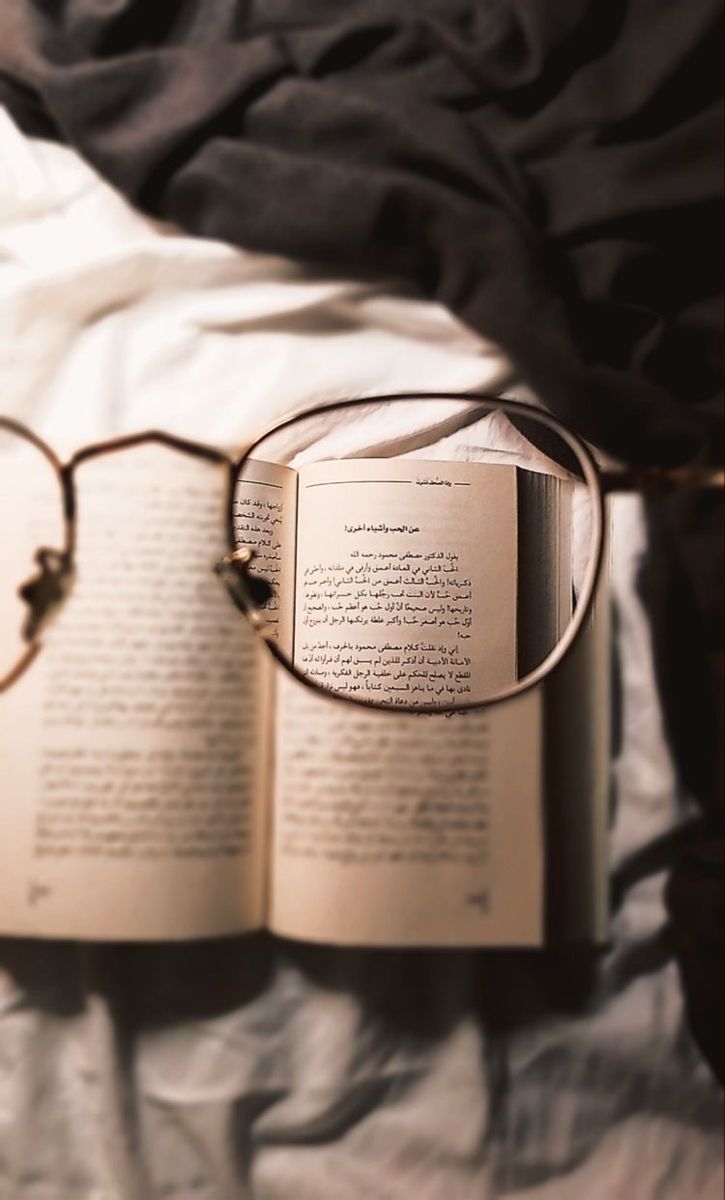 an open book with glasses on top of it