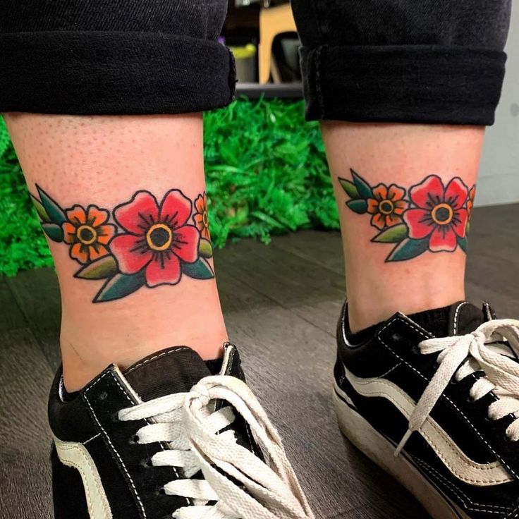 a woman's foot with flowers on her left ankle and the other side of her leg