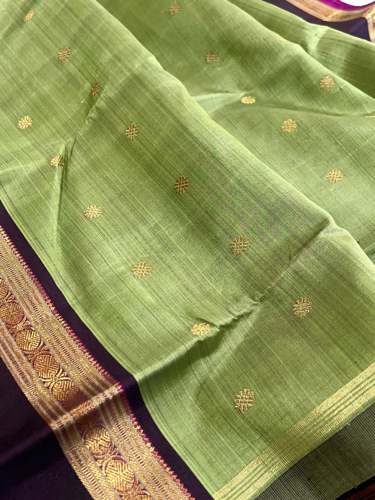 This beautiful saree in pistachio green shot black is handwoven. The rettai pettu border in betelnut shot with black color and purple selvedge is flanked in chakram and geometric motifs in gold zari. The body is adorned with chakram motifs while the grand pallu is decorated with paisleys along with traditional motifs in gold zari. Blouse piece is in betelnut shot with black color. Approximate Length 6.5 mtrs (inclusive of blouse length) Height - 46 - 52" Approximate weight - 1.6 lbs Saree comes Green Ceremonial Saree For Diwali, Green Slub Silk Dupatta With Traditional Patterns, Ceremonial Green Saree With Pallu, Green Traditional Wear With Zari Weaving For Rituals, Black Tussar Silk Saree With Weaving Work, Ceremonial Green Saree With Cutdana, Ceremonial Green Paithani Silk Saree, Ceremonial Green Traditional Wear With Zari Weaving, Green Saree For Rituals