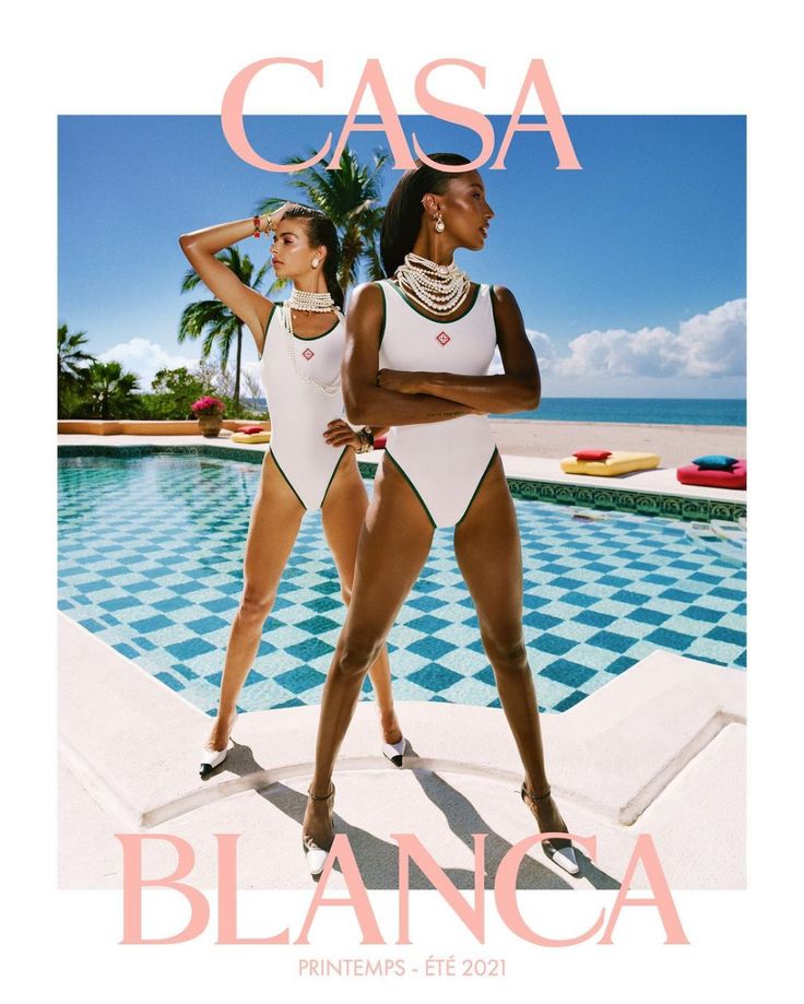 two women in white swimsuits standing next to a swimming pool with the words casca on it