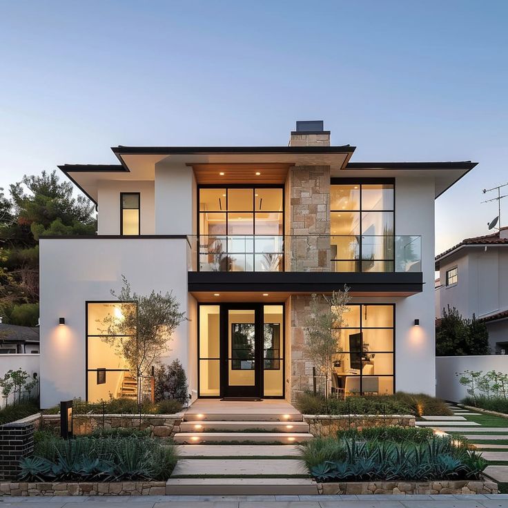 a modern house with lots of windows and steps leading up to the front door area