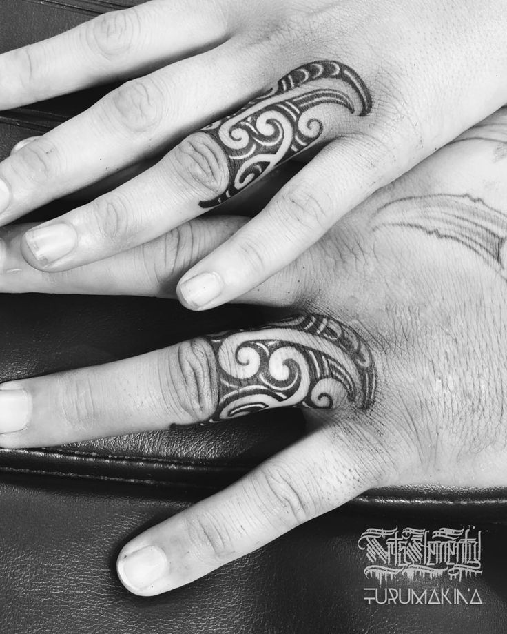 two hands with tattoos on their fingers