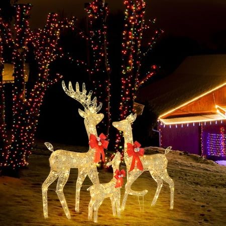 two reindeer statues with lights in the background