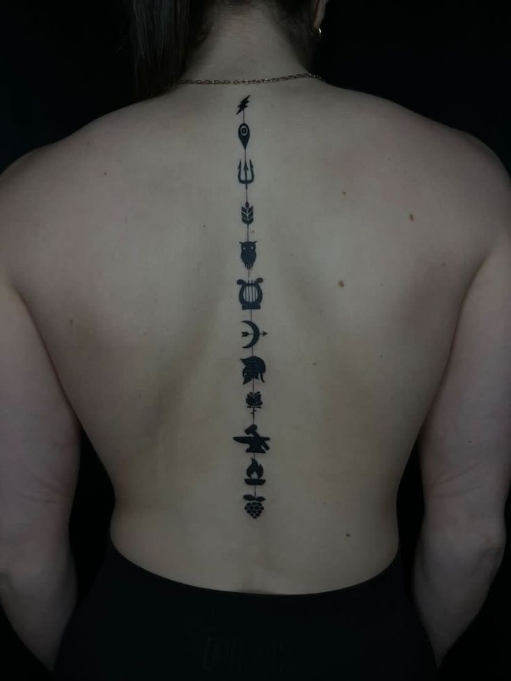 the back of a woman's body with tattoos on her upper and lower back