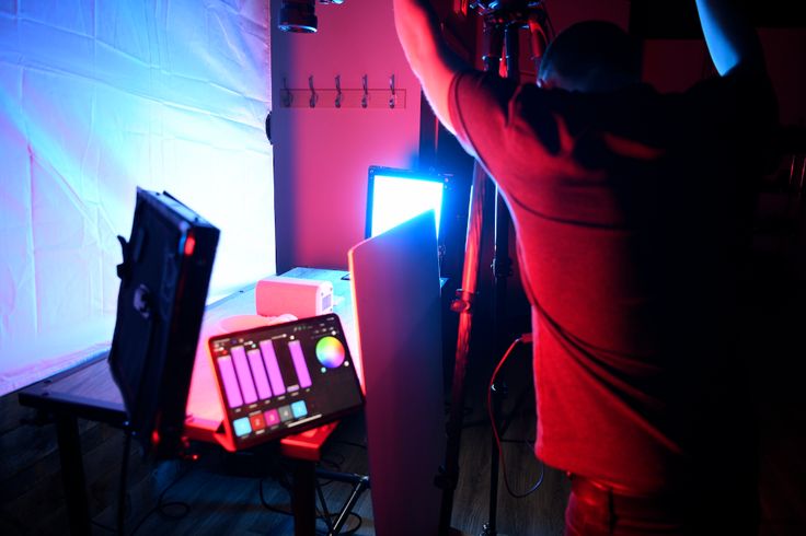 a person standing in front of a television and sound equipment with their hands up to the ceiling