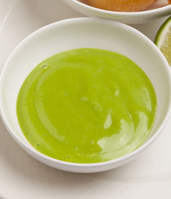 two bowls filled with green liquid next to sliced limes