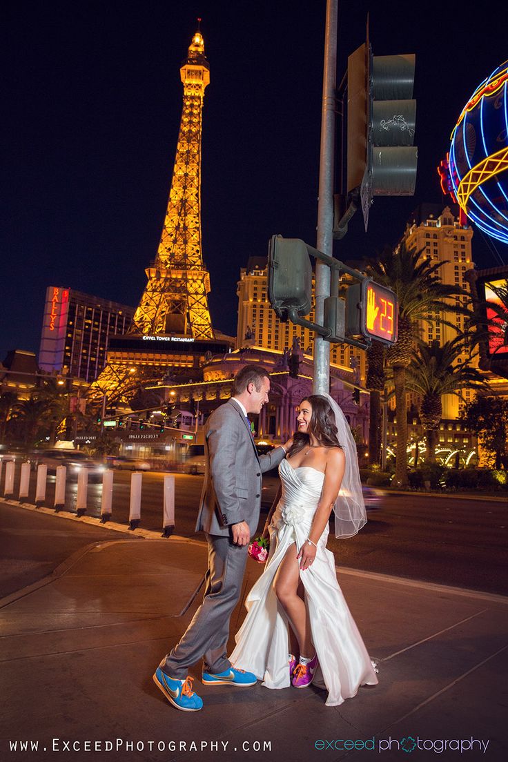 a bride and groom pose for a photo in front of the eiffel tower