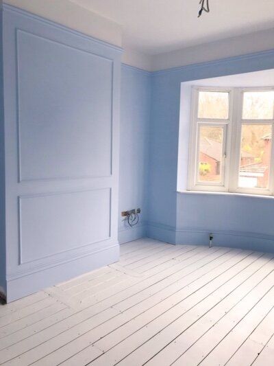 an empty room with blue walls and white floors