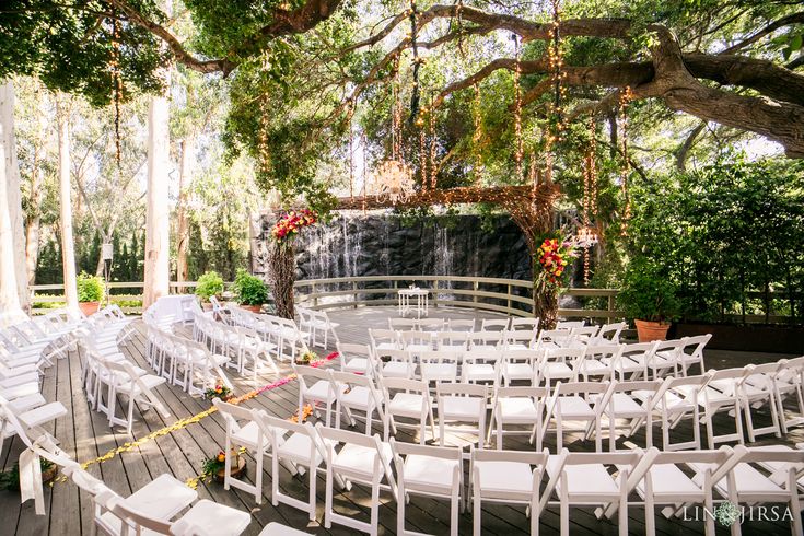 an outdoor ceremony setup with white chairs