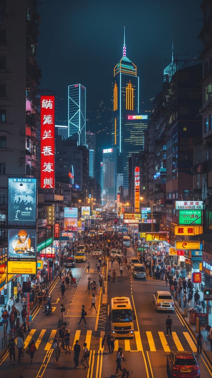 a city street filled with lots of traffic and tall buildings in the background at night