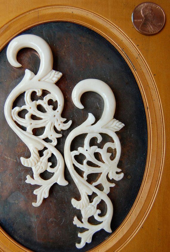 two white decorative objects sitting on top of a wooden table