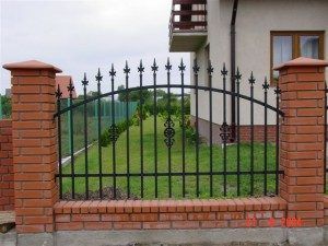 an iron gate is in front of a brick house