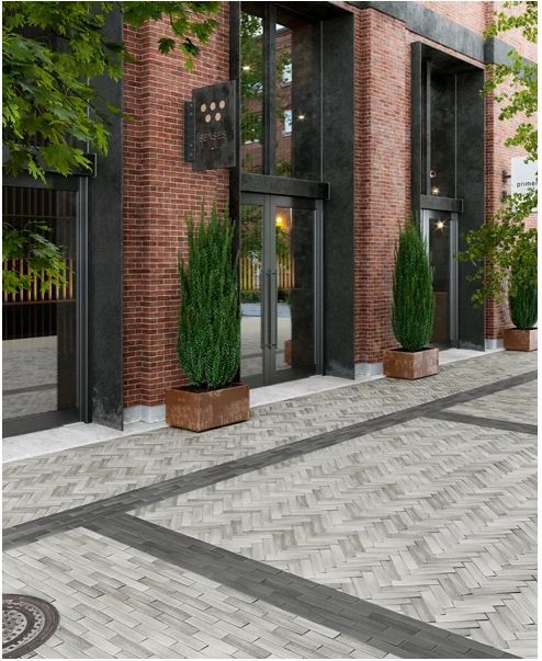 a brick building with two tall planters on the sidewalk