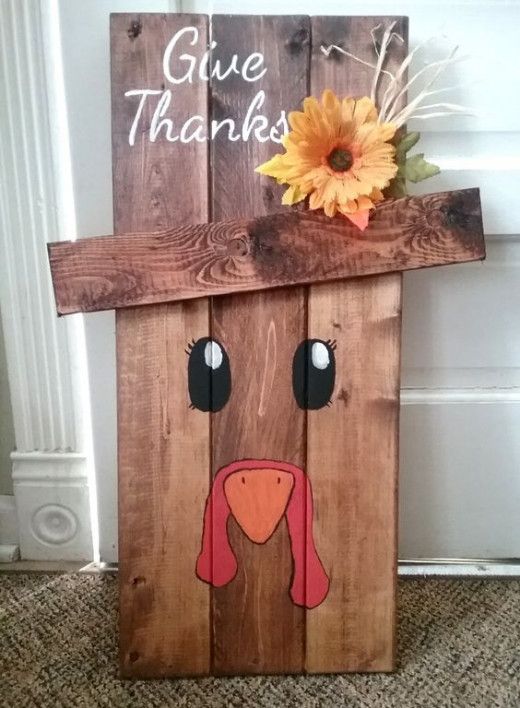 a wooden sign with a turkey face painted on it's side and the words give thanks