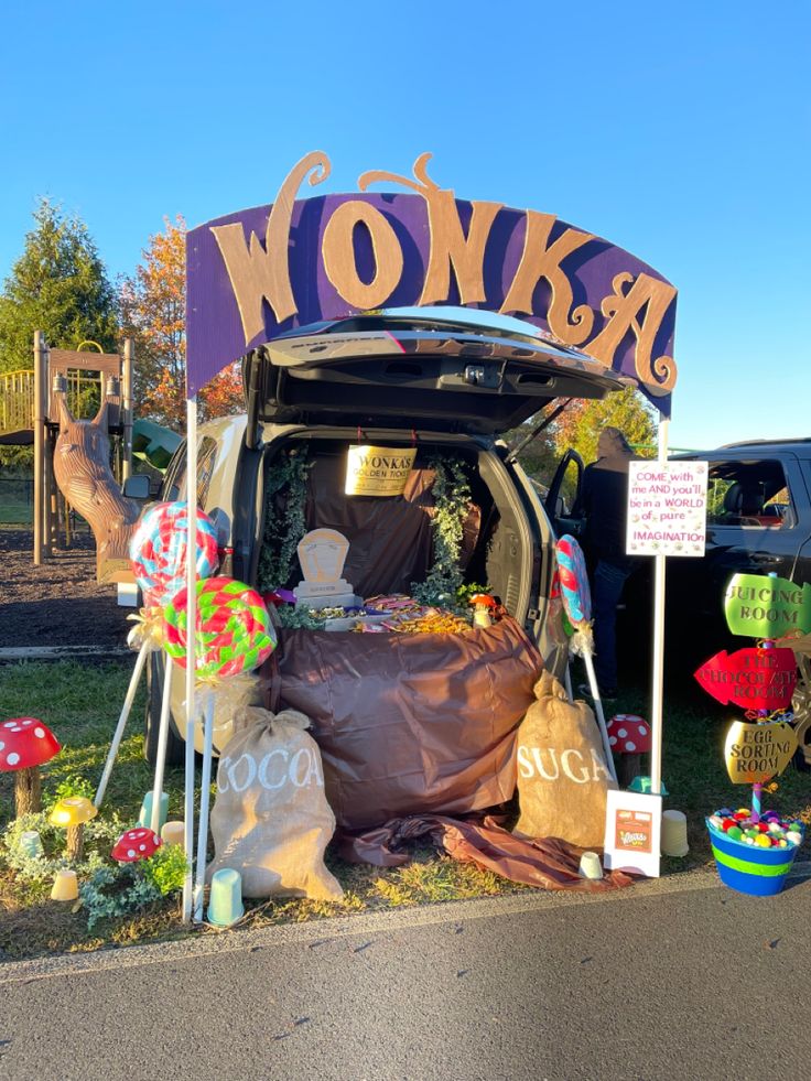 a car covered in fake animals and decorations on the side of the road with words wonka above it