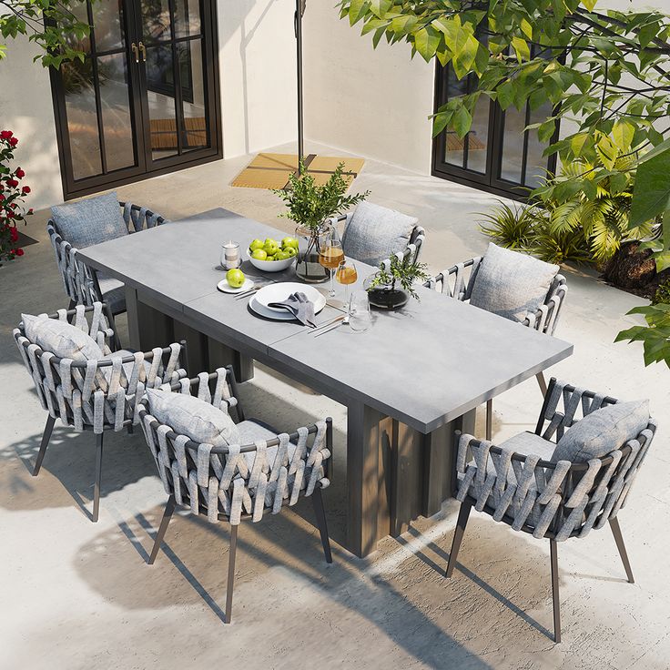 an outdoor table with chairs and plates on it